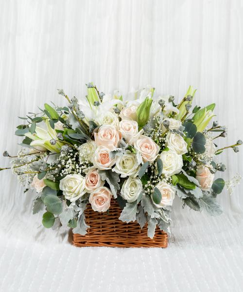 กระเช้าดอกไม้สด ตกแต่งด้วยดอกไม้โทนสีขาวและสีส้มลงในกระเช้าทรงสี่เหลี่ยมสีน้ำตาล