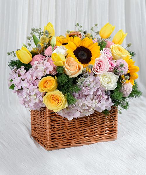 กระเช้าดอกไม้สด โดดเด่นด้วยดอกทานตะวัน ตกแต่งด้วยดอกไม้หลากสีหลายชนิดในกระเช้าทรงสี่เหลี่ยม