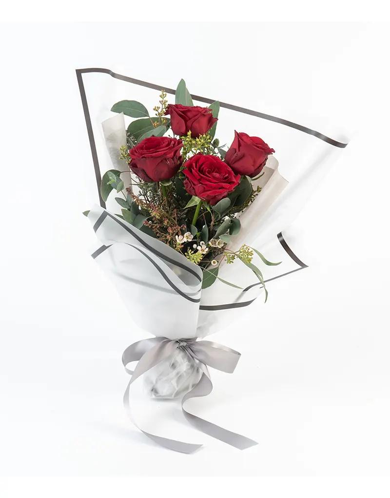 ช่อดอกกุหลาบแดง 4 ดอก แซมด้วยแคสเปีย ซัลลี่หงส์ ยูคาลิปตัส ห่อด้วยกระดาษไขสีขาวตัดขอบสีดำ เสริมด้วยริบบิ้นสีเงินสุดลงตัว
