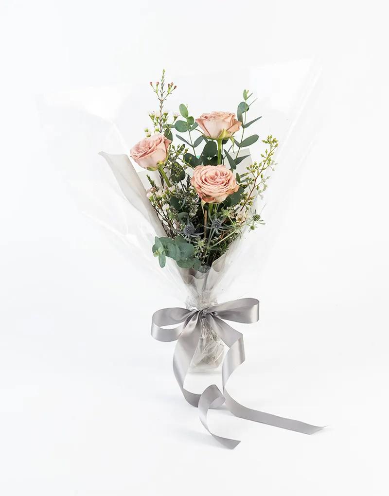 ช่อดอกไม้กุหลาบโทนสีคาปูชิโน่ ห่อด้วยกระดาษใส ผูกด้วยริบบิ้นที่รับกับดอกไม้ เป็นตัวแทนความรักที่มอบให้กันในทุกโอกาส
