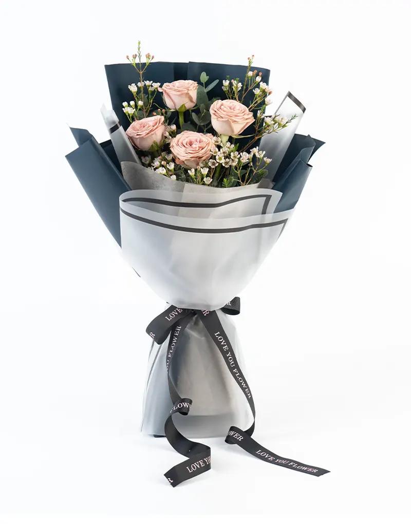 ช่อดอกกุหลาบสีคาปูชิโน่ แซมด้วยดอกแว๊กซ์ แคสเปีย อิลิเจียม ยูคาลิปตัส พร้อมห่อด้วยกระดาษคราฟสีกรมและกระดาษไขสังเคราะห์ขอบดำ