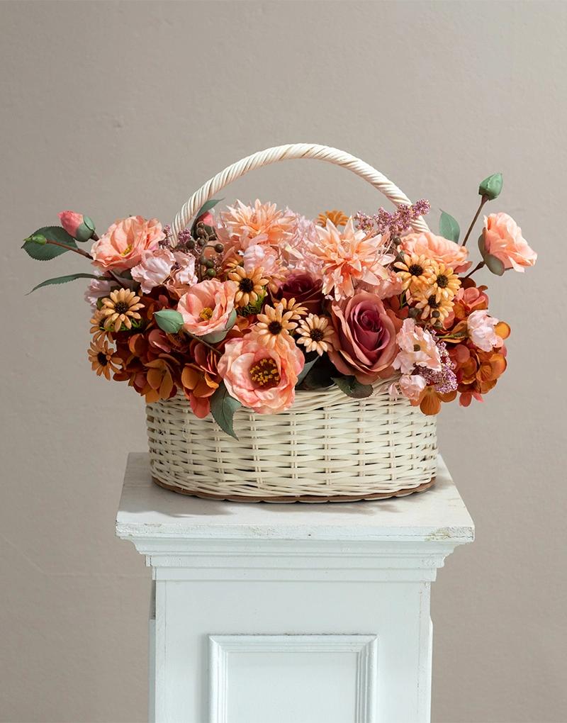 กระเช้าดอกไม้ประดิษฐ์ BPL003 จัดด้วยดอกไม้หลายชนิดที่มีโทนสีชมพู สีส้ม และสีน้ำตาลอบอุ่น ในกระเช้าสีขาว