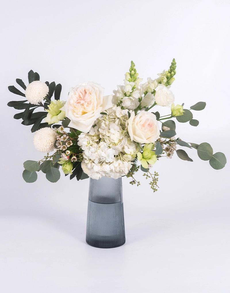 แจกันดอกไม้โทนสีขาว ร้าน Love You Flower จัดในแจกันใสสีเทาเหมาะกับแสดงความยินดี หรือมอบให้ผู้ใหญ่ คุ้มค่า ส่งฟรี 