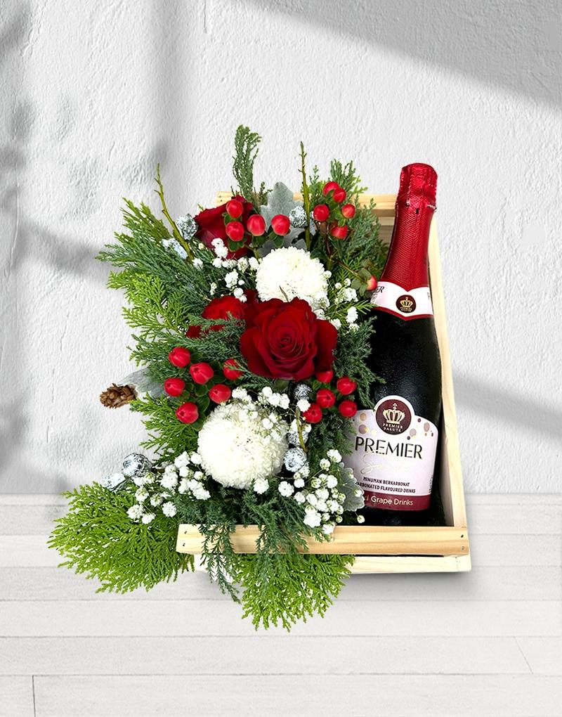 Fresh flower basket with Sparkling Joy carbonated beverage, decorated in red and green Christmas tones.