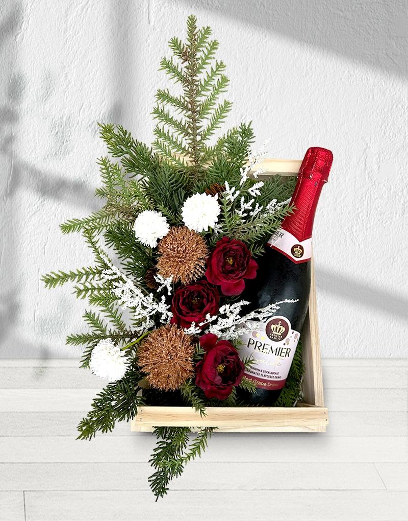 Carbonated grape drink, a gift basket with artificial flowers on a light wood basket.