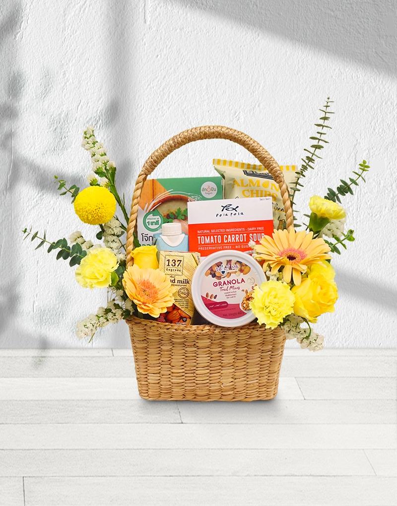 Health Gift Basket, Healthy Hamper adorned with bright yellow-toned flowers.