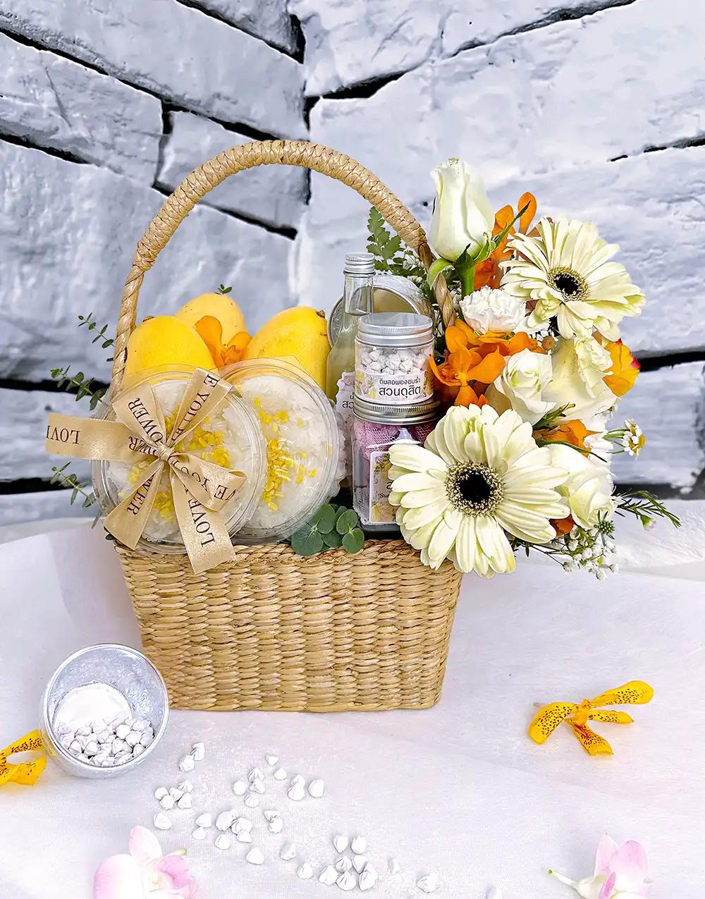 Songkran gift basket BFS009 with mango sticky rice and cooling Thai aroma set, adorned with orange-tone flowers.