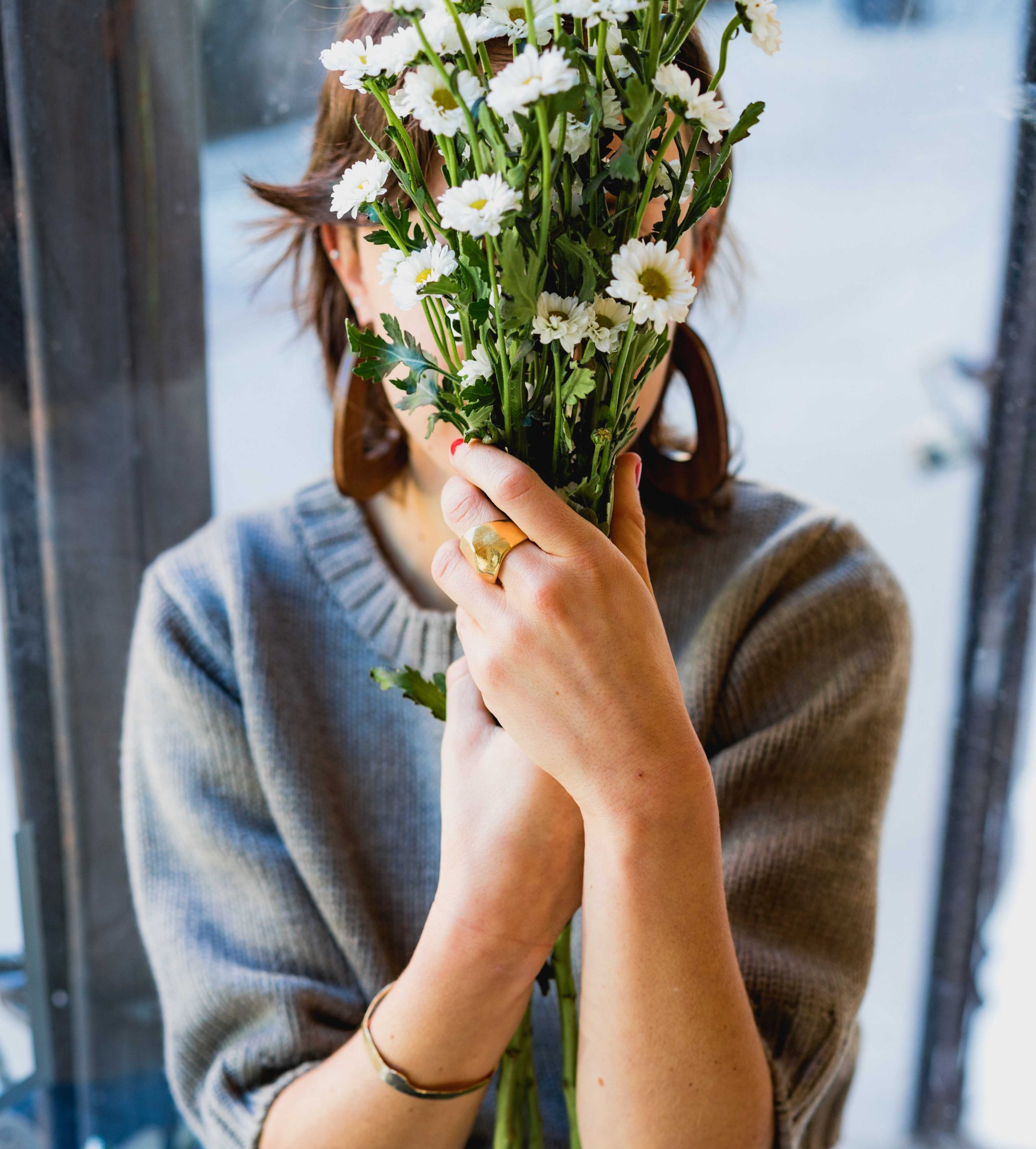 ผู้หญิงซ่อนใบหน้าของตัวเองหลังช่อดอกไม้